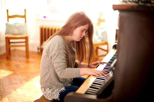 Girl sitting at the piano playing